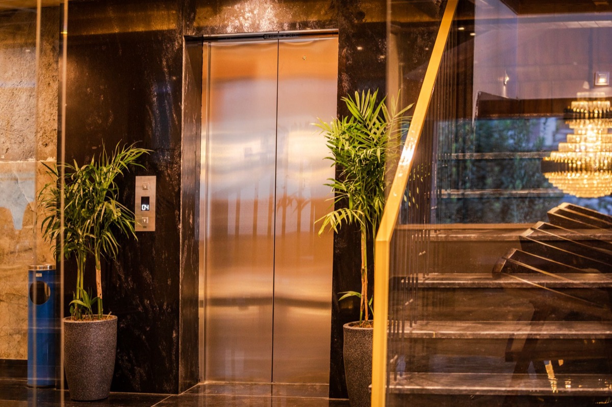 リゾートホテルのラウンジ with marble floors and glass elevators