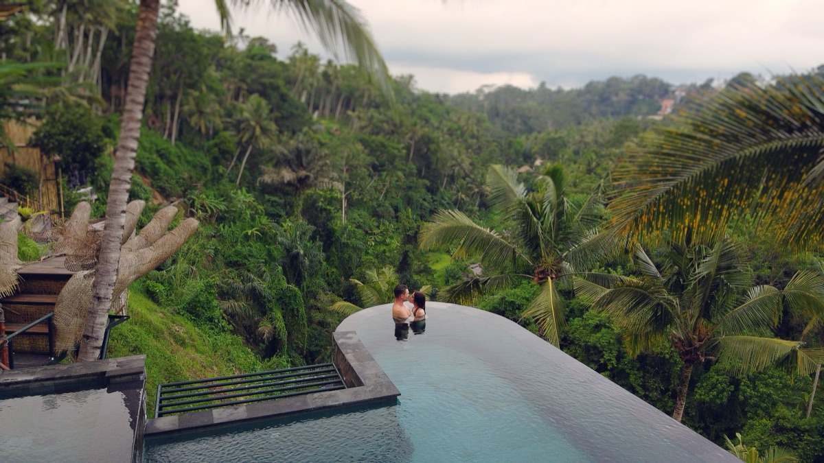 Lush green landscape with resort building and infinity pool