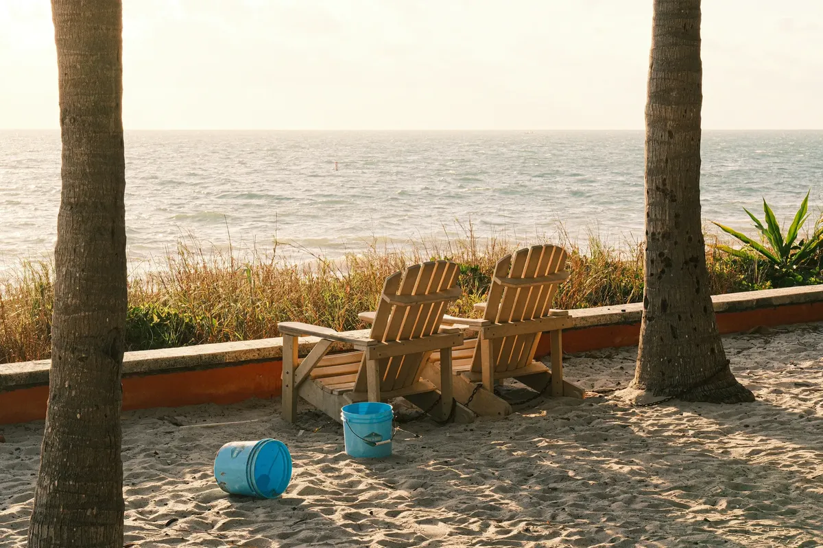 Serene beach view with wooden chairs and ocean backdrop in Key Biscayne, FL.