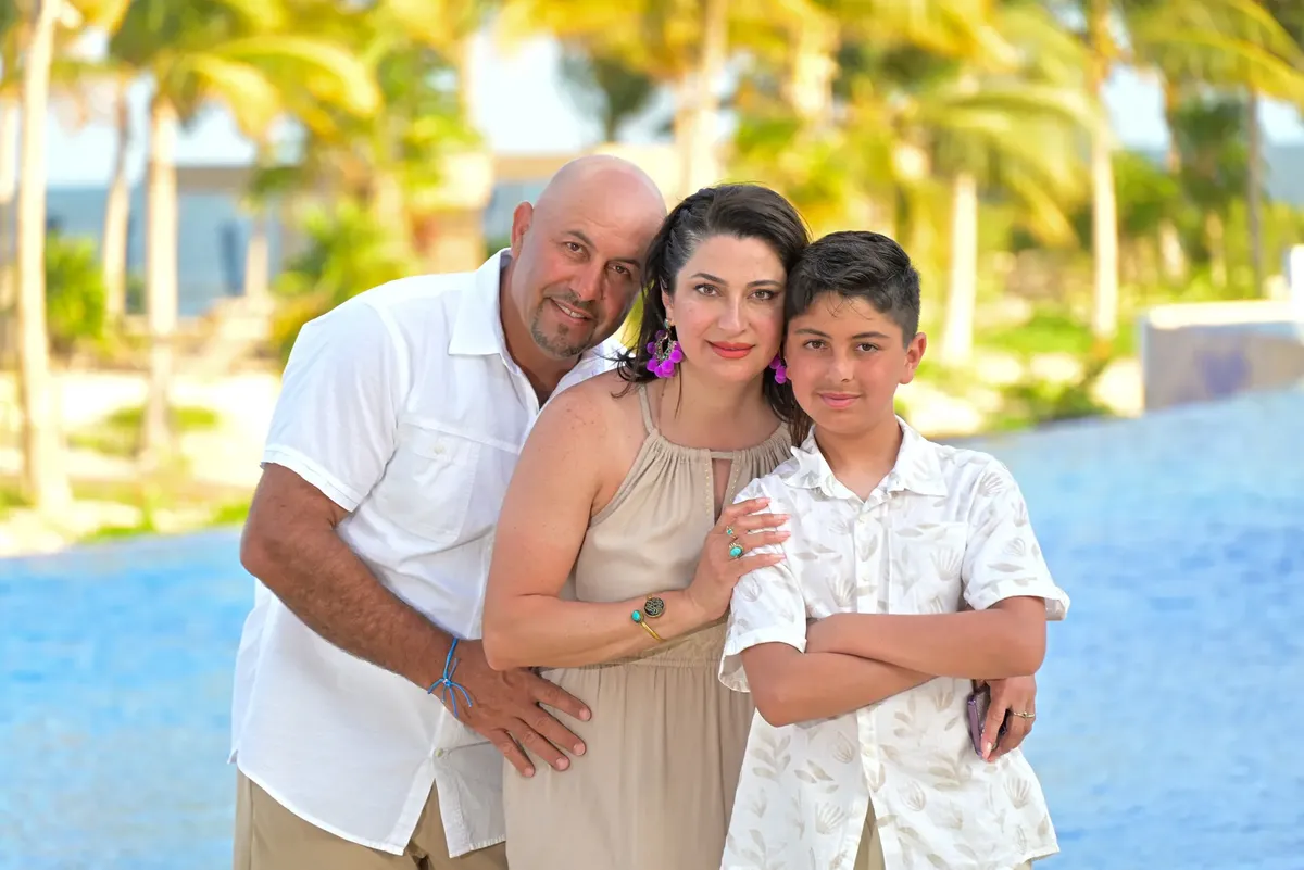 Family posing together at a tropical resort, capturing a happy moment.